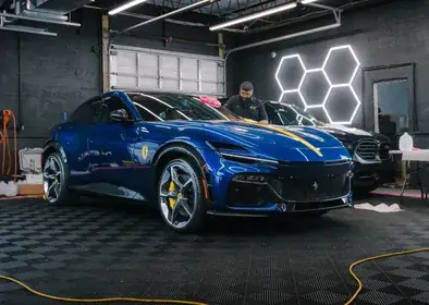 Ecophant Auto technician detailing a blue Ferrari Purosangue in the Boca Raton studio